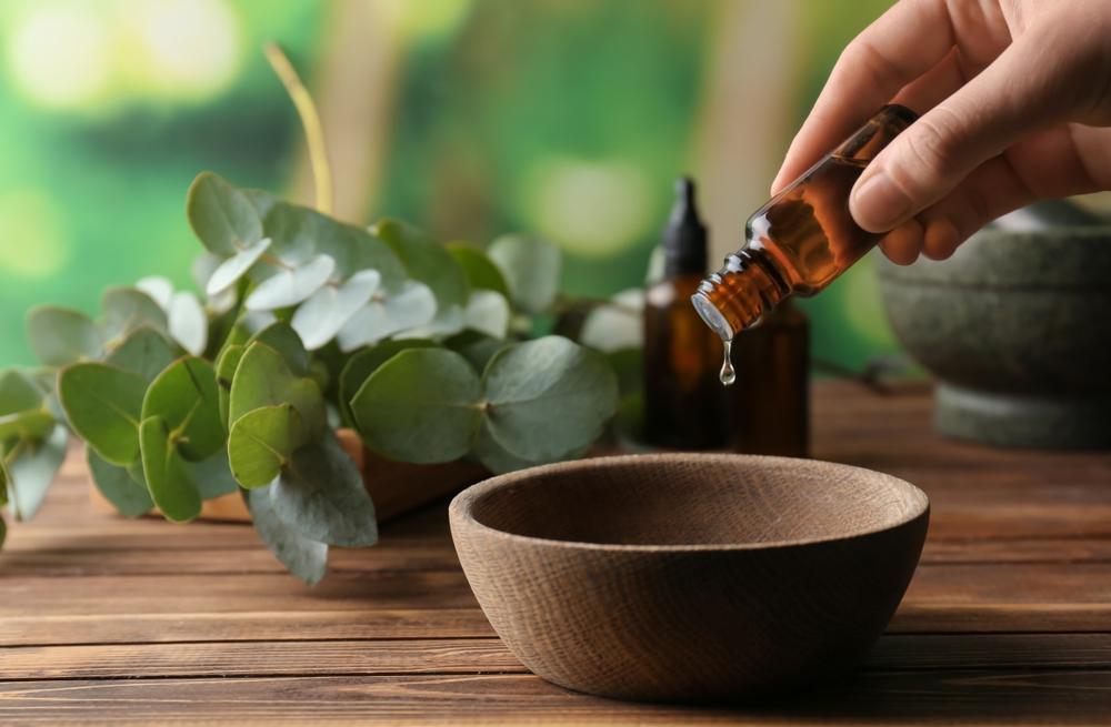 صورة تظهر امرأة تسكب زيت الأوكالبتوس العطري برفق